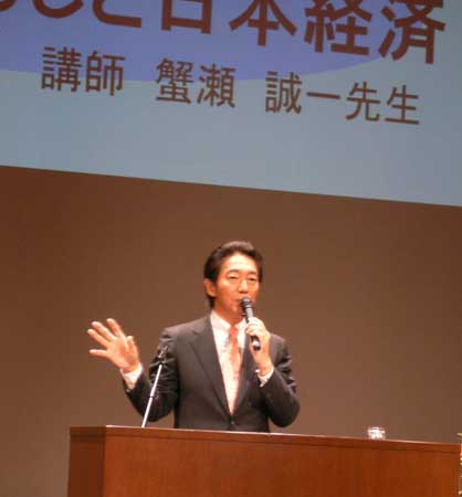 壇上で講演をする蟹瀬誠一氏の様子